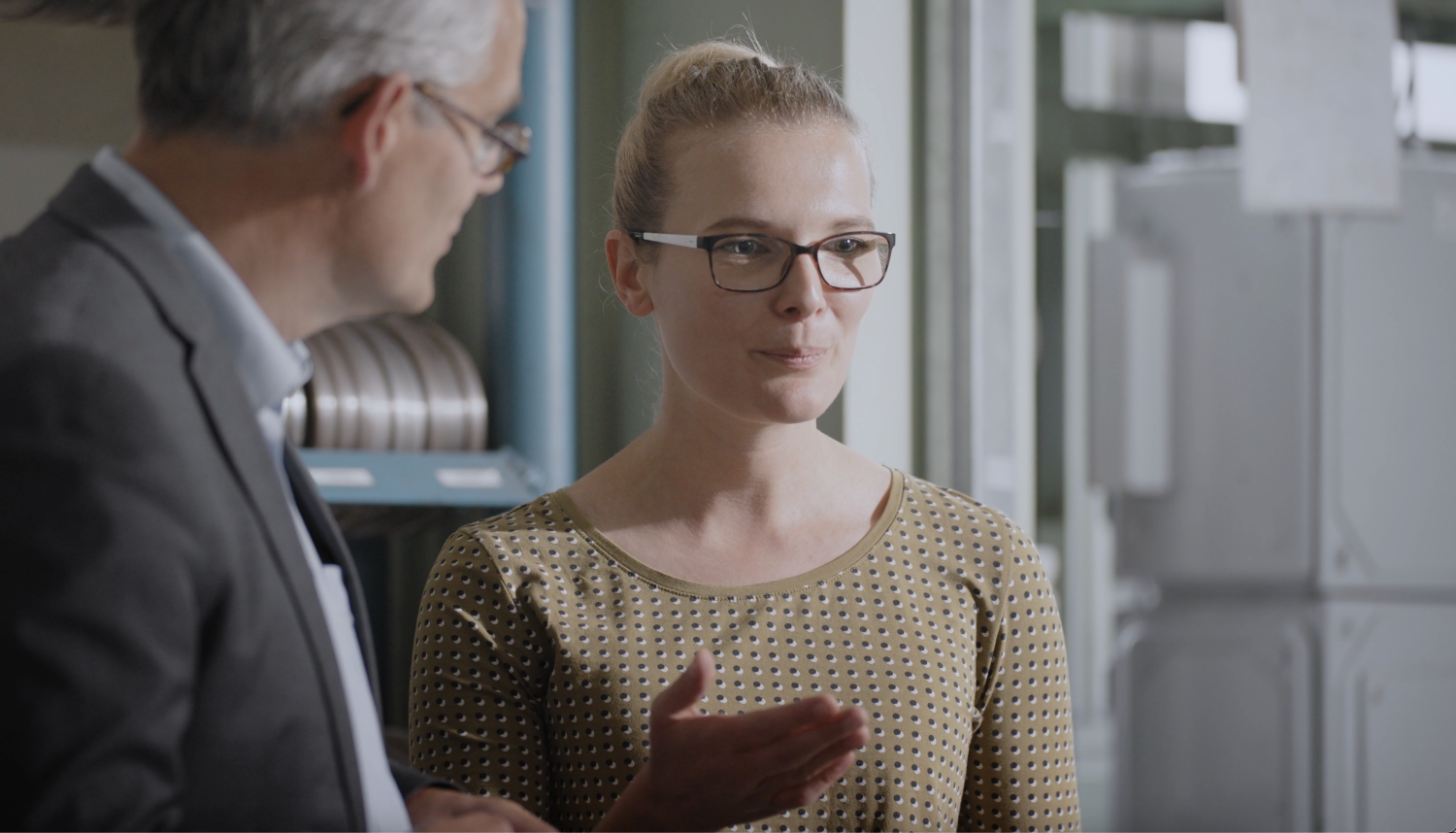 Woman standing next to man explaining something.